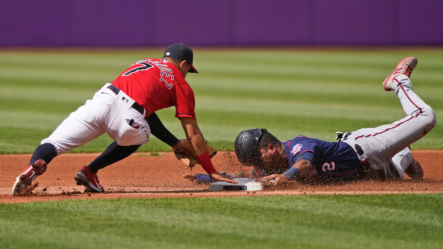 Minnesota Twins' Luis Arraez, right, tries to steal to second base as Cleveland Indians' Cesar Hernandez, left, makes the tag in the first inning of a baseball game, Saturday, May 22, 2021, in Cleveland. (AP Photo/Tony Dejak)