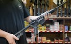An employee holds an AR-15 style rifle inside Clark Brothers Gun Shop in Warrenton, Va.