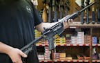An employee holds an AR-15 style rifle inside Clark Brothers Gun Shop in Warrenton, Va.