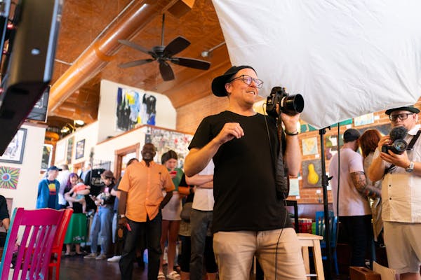 Photographer Josh Madson, center, prepared to photograph residents June 10 inside the Coffee Hag cafe in Mankato, as part of his expansive portrait co