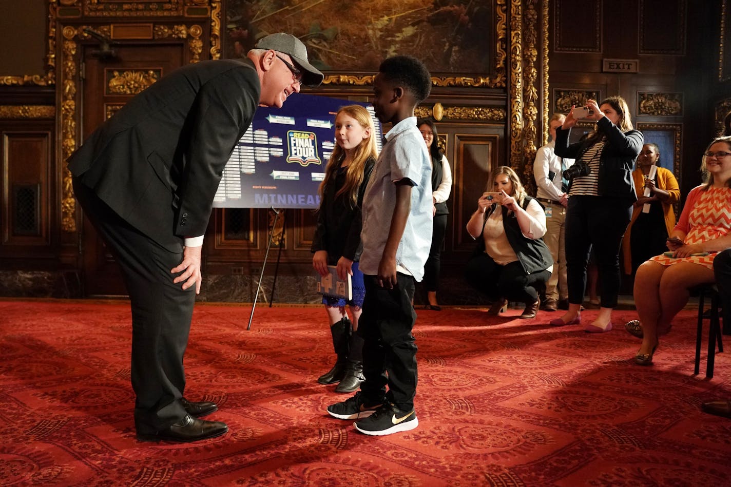 Gov. Tim Walz spoke with Mark Gant, 9, a third grader at Galtier Community Elementary School, and Sophia Kenney, 9, a third grader at Buffalo Lake-Hector-Stewart Elementary School, during a meet-and-greet with teachers and principals from the top four schools in the Read to the Final Four program to recognize their work in encouraging children to read Tuesday.