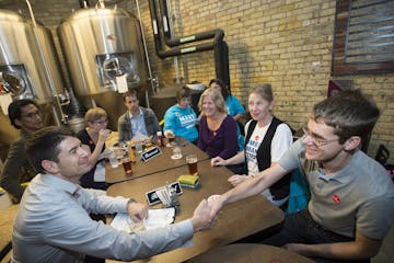 St. Paul Ward 4 City Council incumbent Russ Stark. left, shook hands with supporter Karl Carter at Tuesday night's DFL election party at Urban Growler