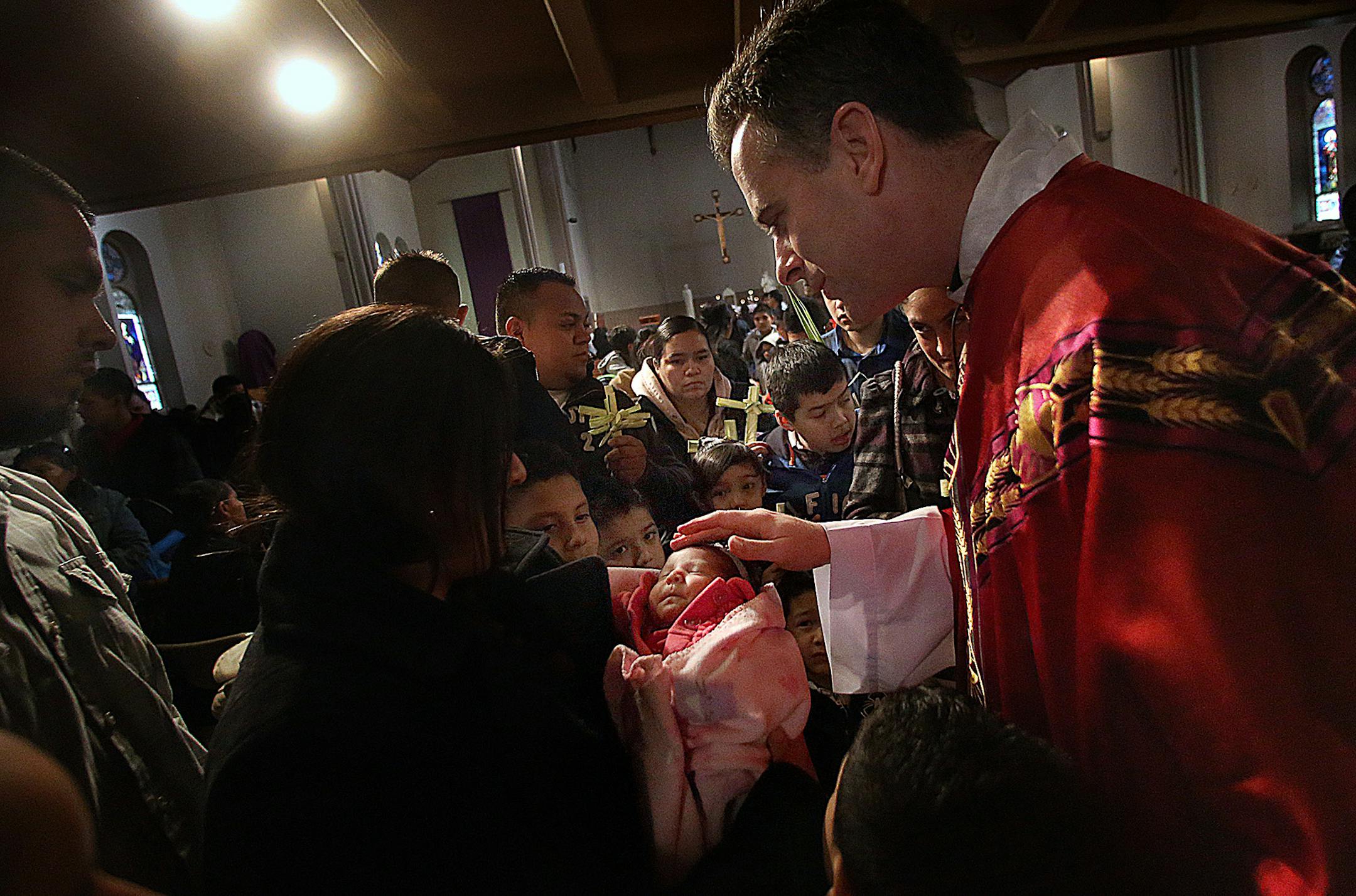 Fr. Joseph Williams offered more personal blessings to families following the Palm Sunday service. ] (JIM GEHRZ/STAR TRIBUNE) / March 24, 2013 / 9:00 AM Minneapolis, MN &#x221a;&#xea; BACKGROUND INFORMATION- St. Stephen&#x221a;&#xef;s Church in south Minneapolis is in the midst of a &#x221a;&#xed;rebirth,&#x221a;&#xec; transitioning from a predominantly white congregation to one that&#x221a;&#xef;s mainly Latino and Spanish-speaking. Pastor Joseph Williams has shepherded the church through the c