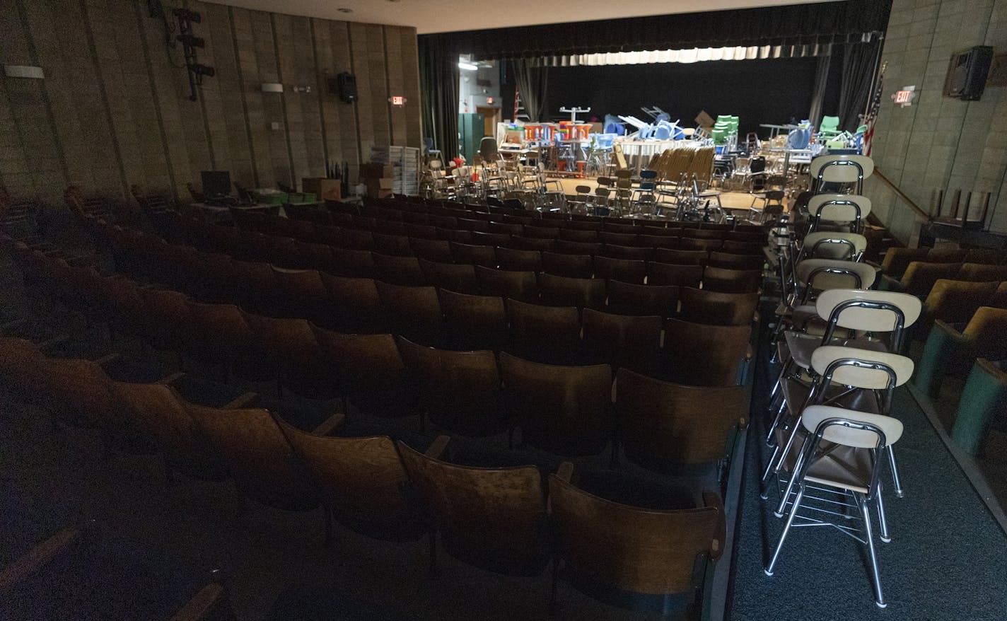 Desks and supplies sit stacked in the auditorium which is being used as storage during the coronavirus outbreak at the Osborn School, Tuesday, Oct. 6, 2020, in Rye, N.Y. (AP Photo/Mary Altaffer)