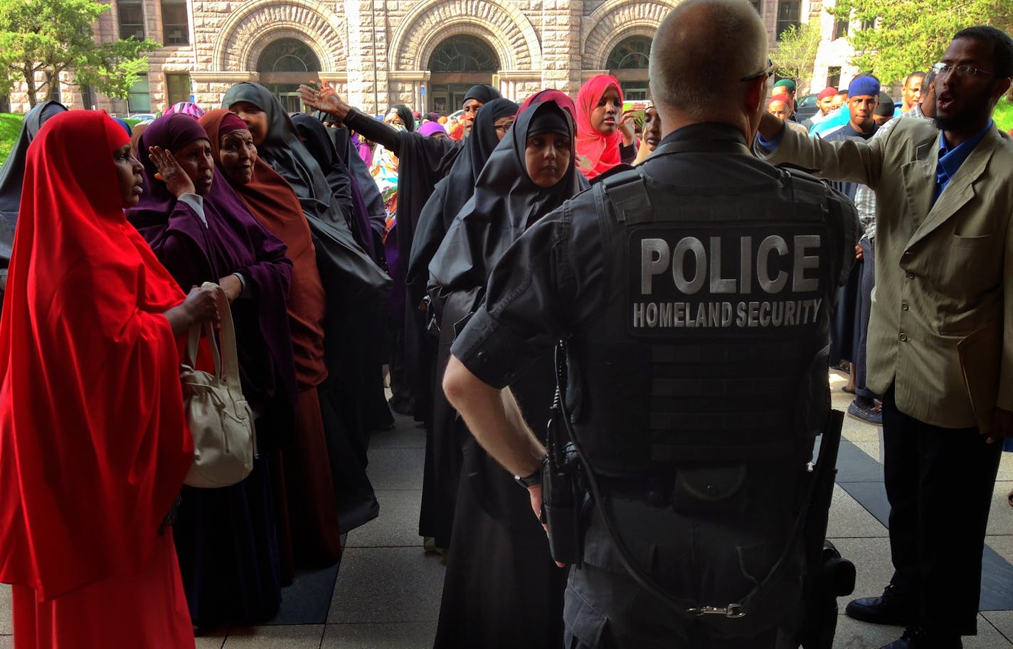 The two Rochester women convicted of raising money for Al-Shabab were sentenced Thursday May 16, 2013 in the U.S. Federal Courthouse in minneapolis. Family and Somali community members turned up in force to support the 2 women . Abdinasir Abdi on the far right a Somali community leader talked with a Homeland security officer at the front door of the Federal court building as community member began to que up to go into the sentencing hearing.