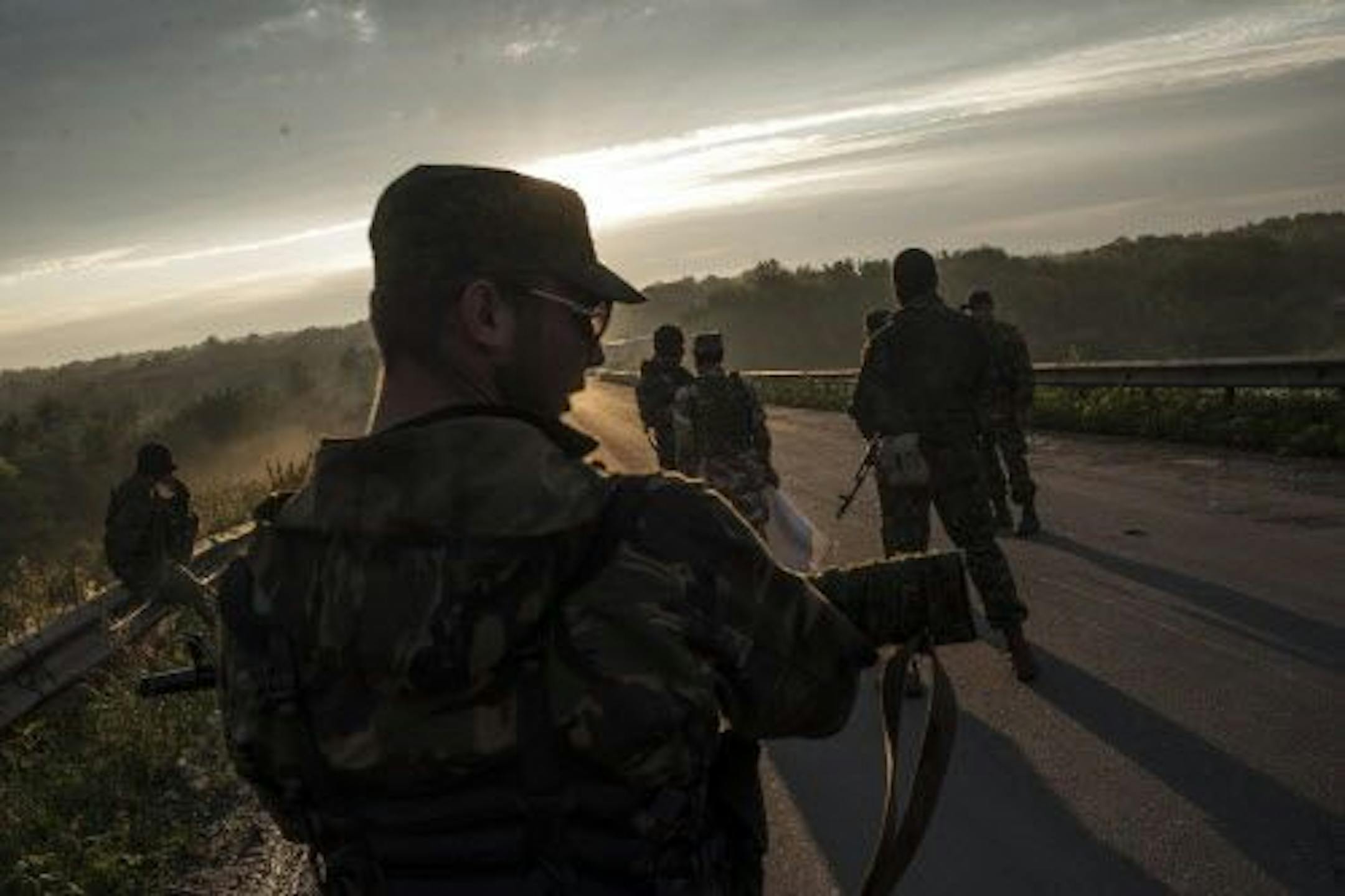 Pro-Russian fighters wait for representatives of the Ukrainian troops at a check point in the village of Karlivka near Donetsk, eastern Ukraine, Wednesday, June 18, 2014, during a handover of the bodies of Ukrainian troops who died in a plane shot down near Luhansk.