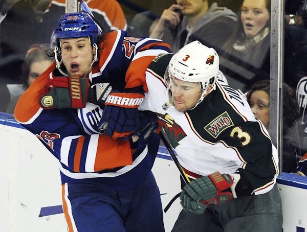 Edmonton Oilers' Ryan Jones, left, checked the Wild's Marek Zidlicky
