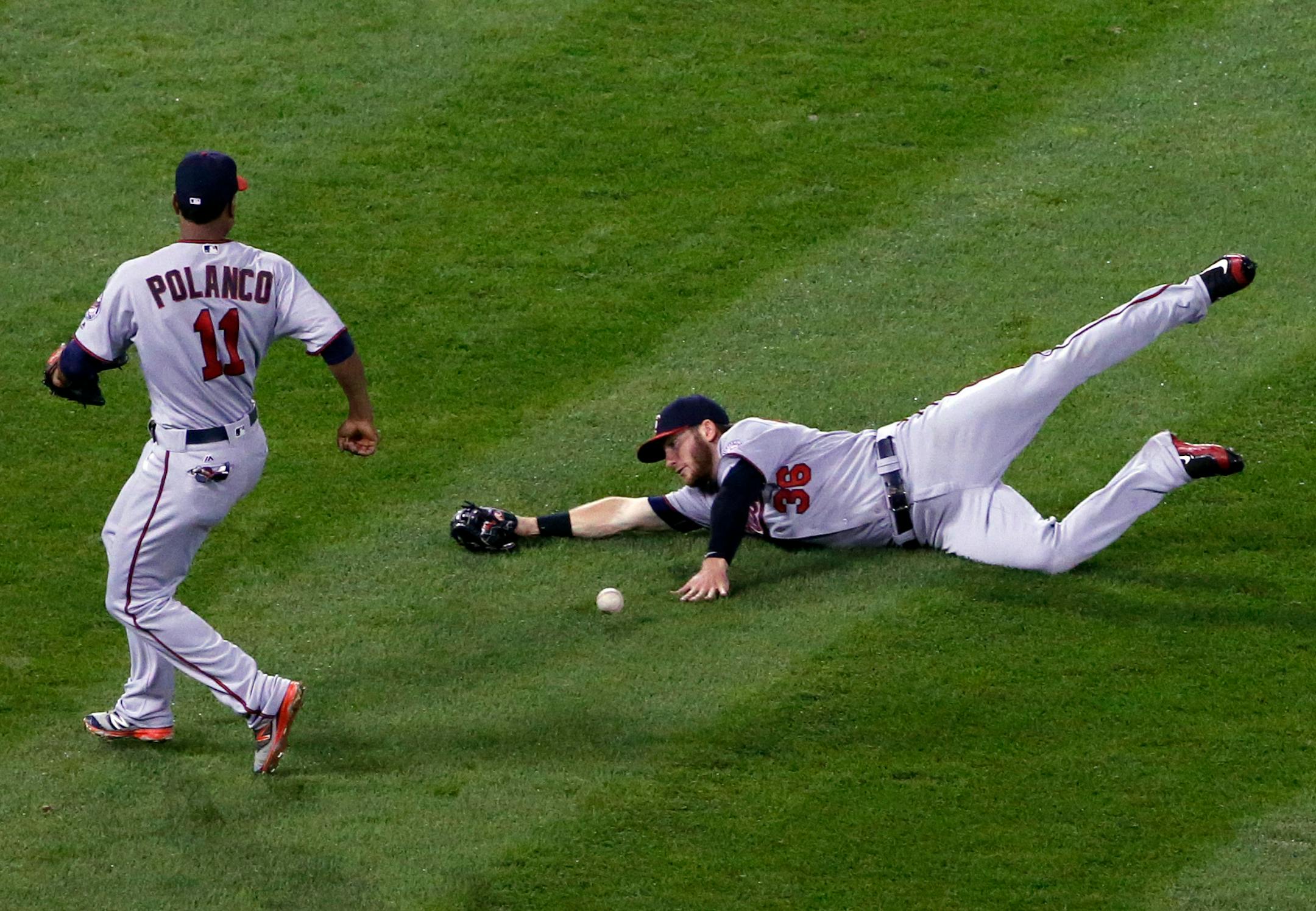 Minnesota Twins left fielder Robbie Grossman, right, cannot make the play on a single by Chicago White Sox's Melky Cabrera as shortstop Jorge Polanco, left, looks on during the fourth inning of a baseball game Friday, Sept. 30, 2016, in Chicago. (AP Photo/Nam Y. Huh)