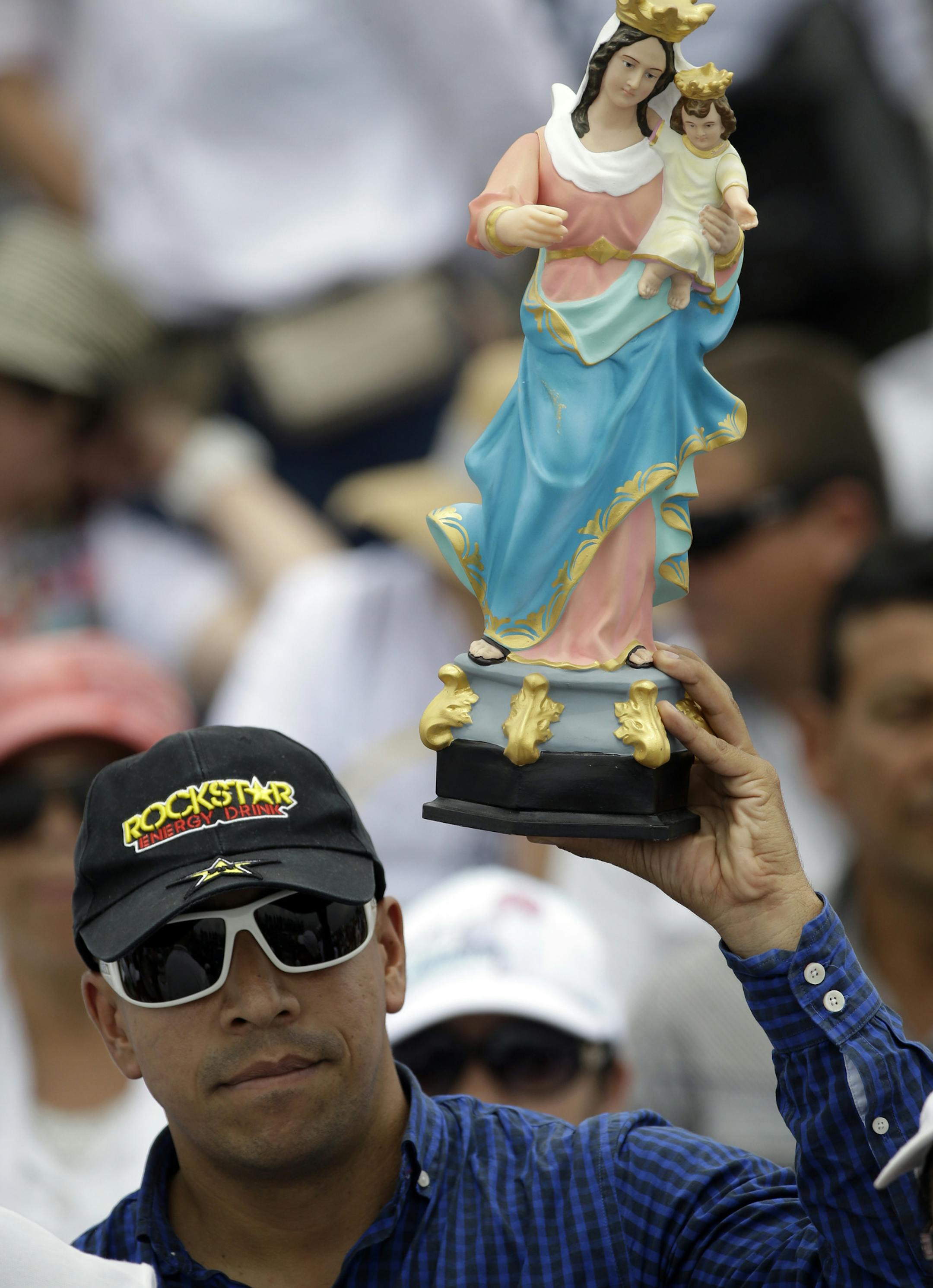 A man holds up a statue of Mary, Help of Christians (Maria Auxiliadora) as Pope Francis celebrates a giant outdoor Mass in Medellin, Colombia, Saturday, Sept. 9, 2017. (AP Photo/Fernando Vergara)