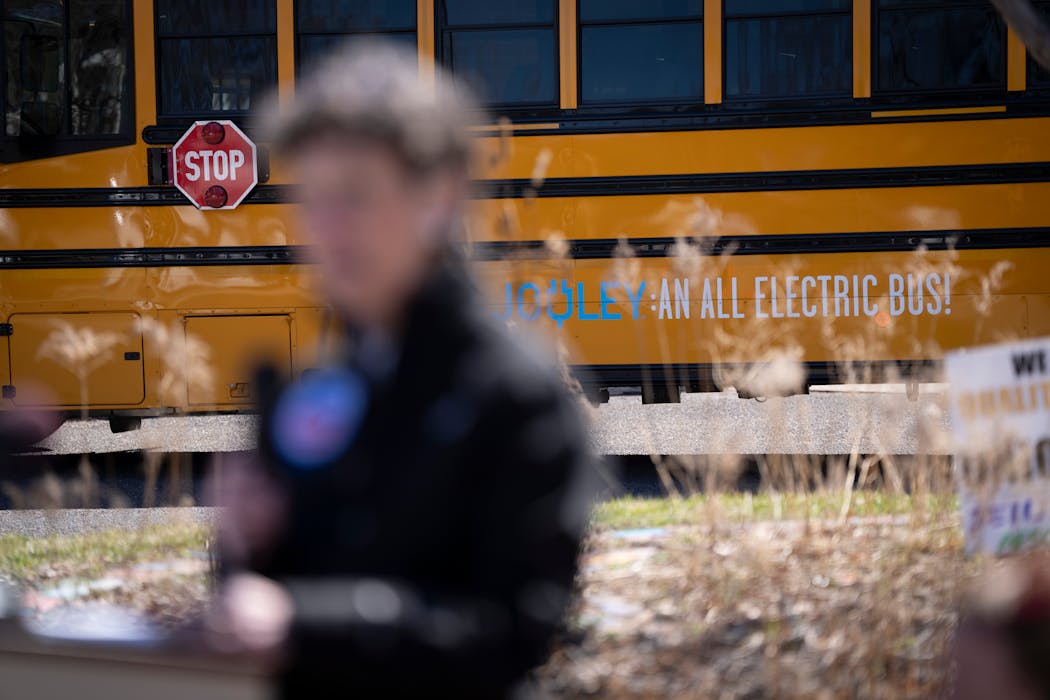 An electric bus is photographed behind Region 5 EPA administrator Debra Shore as she speaks at a news conference at Whittier Elementary School on Tuesday in Minneapolis.