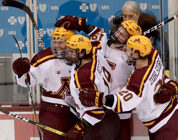 The University of Minnesota's Sampo Ranta, left, celebrates his third period goal with teammates against the University of Wisconsin during the third 