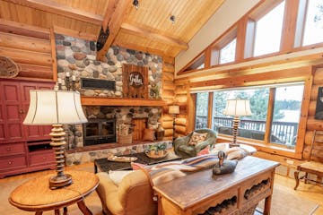 Windows let ample light into the Ely log home while providing vistas of the woods and Burntside Lake. A stone wood-burning fireplace keeps things cozy