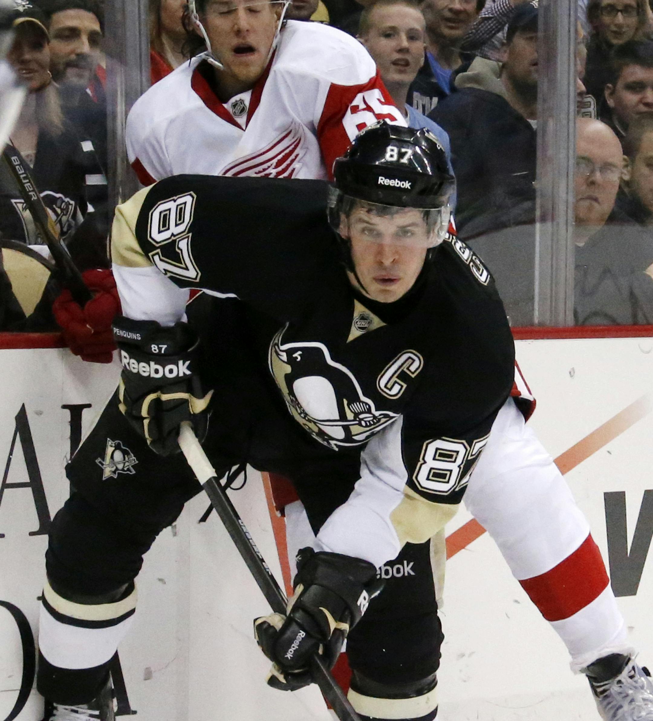 Pittsburgh Penguins' Sidney Crosby (87) collides with Detroit Red Wings' Danny DeKeyser (65) during the second period of an NHL hockey game in Pittsburgh, Wednesday, April 9, 2014. (AP Photo/Gene J. Puskar)