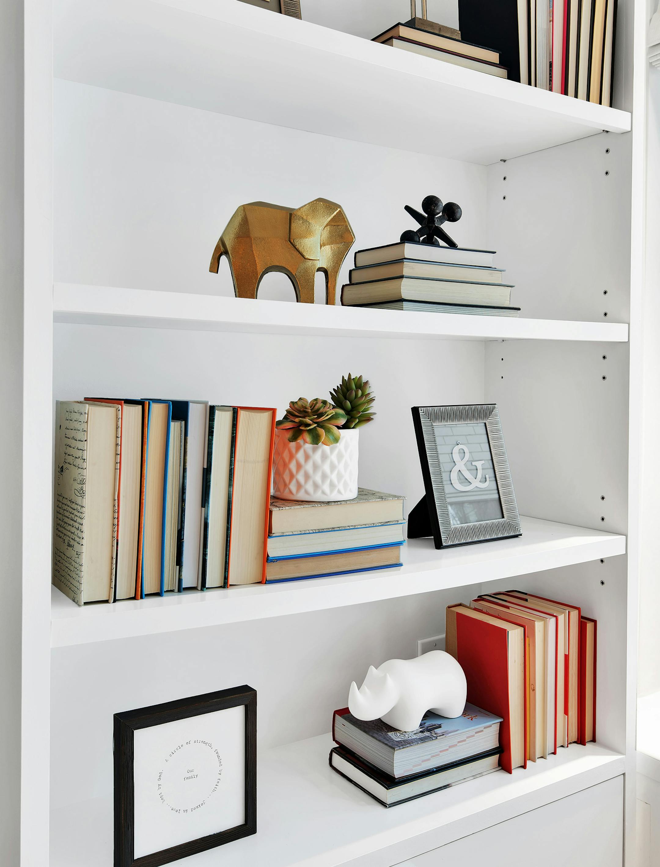 Small gold figurines used to style a bookshelf helps make the bookcase an attractive focal point. (Design Recipes) ORG XMIT: 1222674