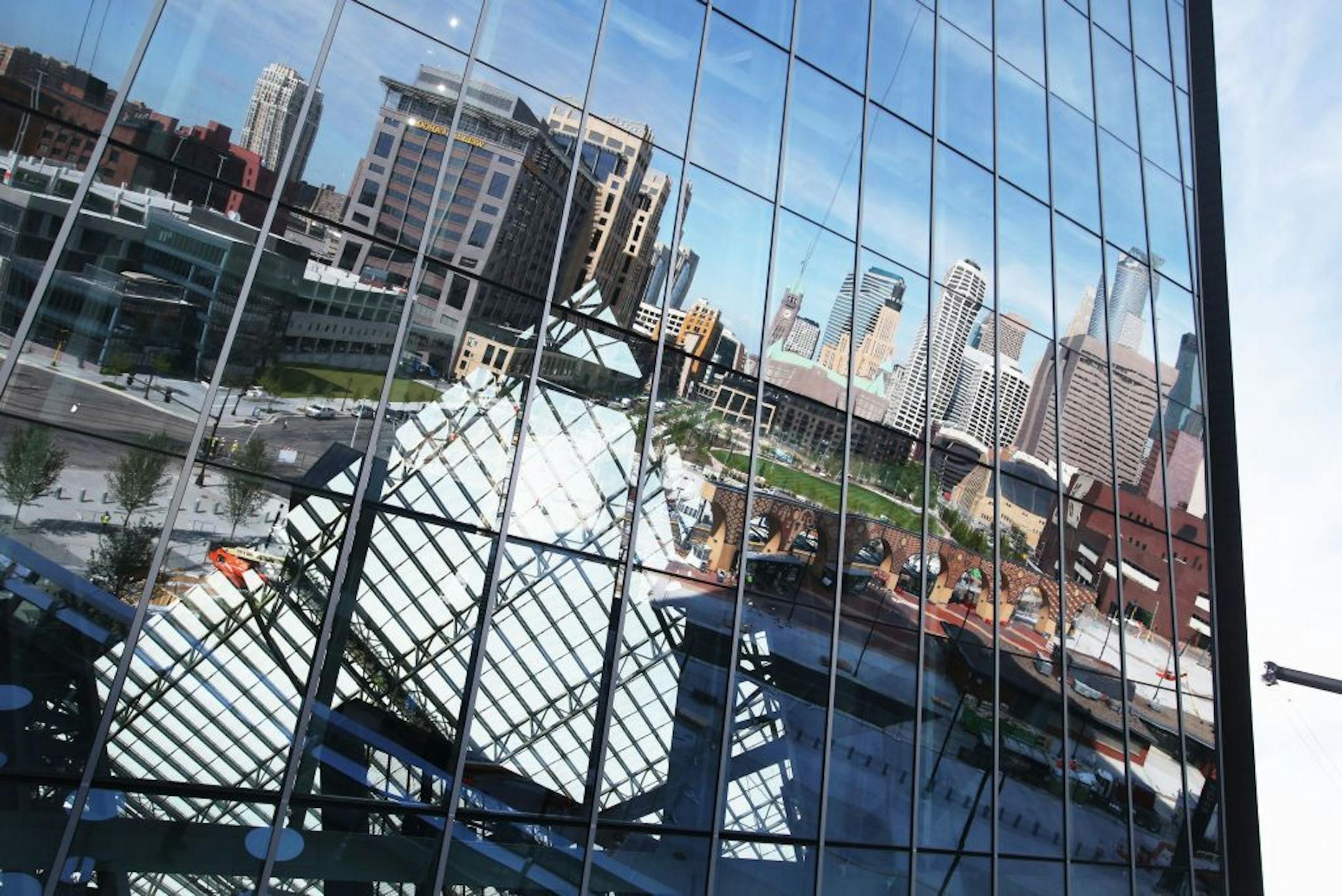 Downtown Minneapolis is reflected on the exterior glass as the see-through roof is visible outside the Mystic Lake Club during a media tour Tuesday, July 19, 2016, at U.S. Bank Stadium in Minneapolis, MN.