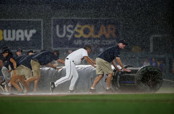 The grounds crew rolled the tarp over the field at the start of a rain delay during the Twins-Royals game at Target Field on Friday.