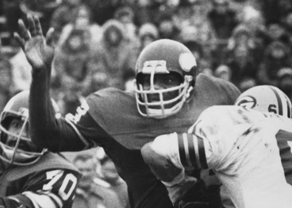 Alan Page bore down on Green Bay quaterback Carlos Brown in 1976. Jim Marshall is No. 70.