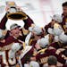 Minnesota-Duluth Bulldogs forward Karson Kuhlman (20) hoisted the NCAA championship trophy over his head while celebrating with teammates following th