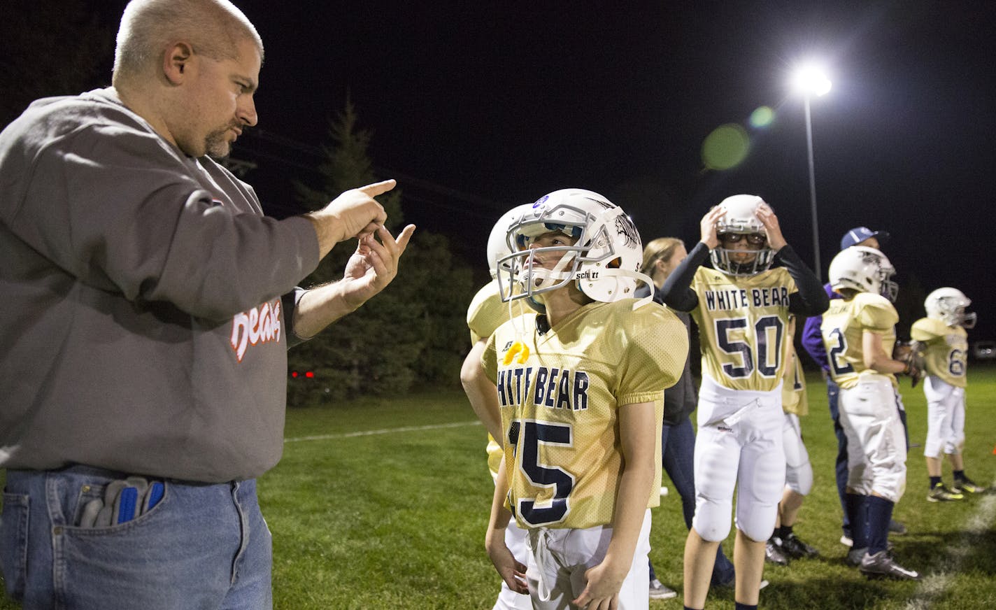 David Nathanson communicates with his son Dov with sign language during a White Bear Lake youth football game at Podvin Park in White Bear Lake on Monday, October 5, 2015. ] (LEILA NAVIDI/STAR TRIBUNE) leila.navidi@startribune.com BACKGROUND INFORMATION: Nathanson and his son are both deaf and communicate with sign language. David also uses a drum to signal his son during youth football games. It's been 25 years since the passage of the American with Disabilities Act, yet the Nathanson family sa