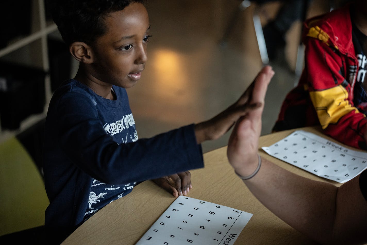 Brit Breitbach teaching reading to her kindergartners high fives Hamza Ahmed left at Stevenson Elementary in Fridley. She is first district administrators to be trained in the LETRS program, she taught her students Monday November 20,2023 in, Fridley, Minn. ] JERRY HOLT • jerry.holt@startribune.com