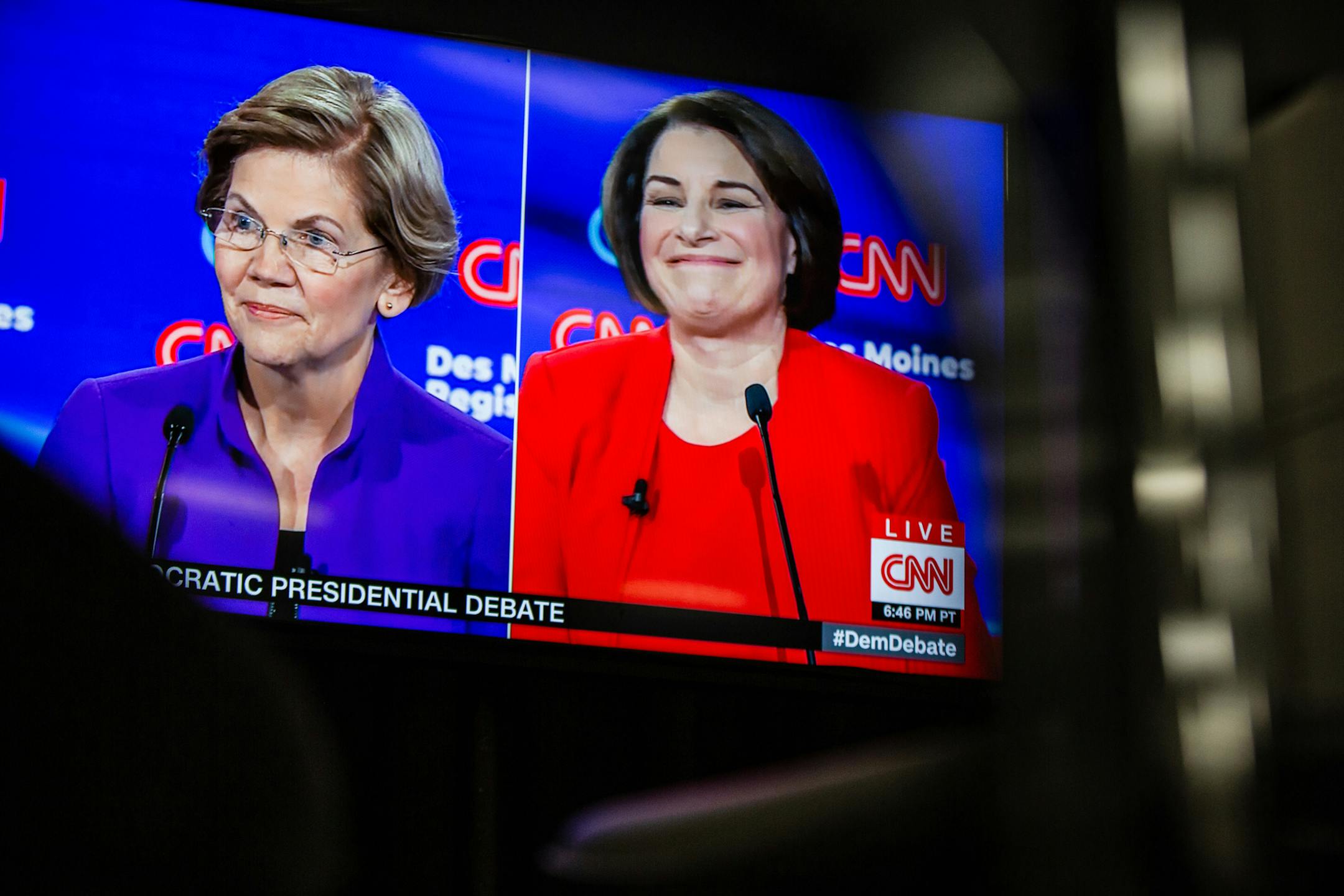 Sens. Elizabeth Warren (D-Mass.) and Amy Klobuchar (D-Minn.) appear on a monitor during a Democratic presidential debate at Drake University in Des Moines, Iowa on Jan. 14, 2020. The New York Times editorial board endorsed the two leading female candidates for the Democratic Party&#x2019;s presidential nomination on Sunday, Jan. 19, 2020, throwing its support behind Klobuchar and Warren. (Jordan Gale/The New York Times)