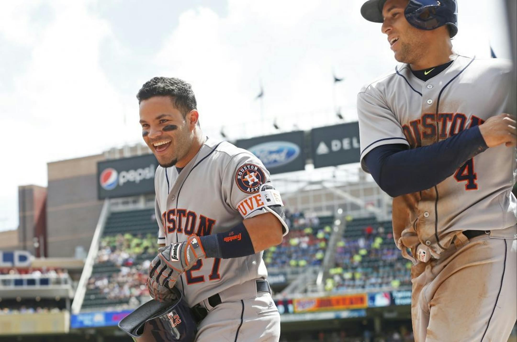 Houston Astros' Jose Altuve, left, and George Springer head to the dugout after scoring in the first inning of a baseball game against the Minnesota Twins Thursday, Aug. 11, 2016 in Minneapolis.