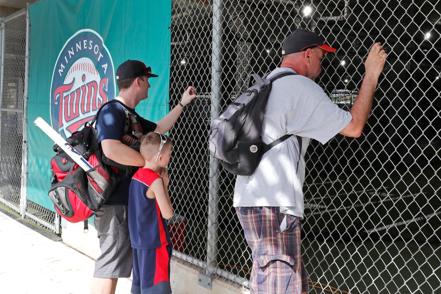 Baseball fans look through a fence at Hammond Stadium after a game between the Twins and the Orioles was canceled on March 12. MLB suspended spring training because of the coronavirus outbreak.