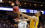 Minnesota's Amir Coffey, right, goes to the basket against Michigan State's Aaron Henry (11) during the first half of a second round men's college bas