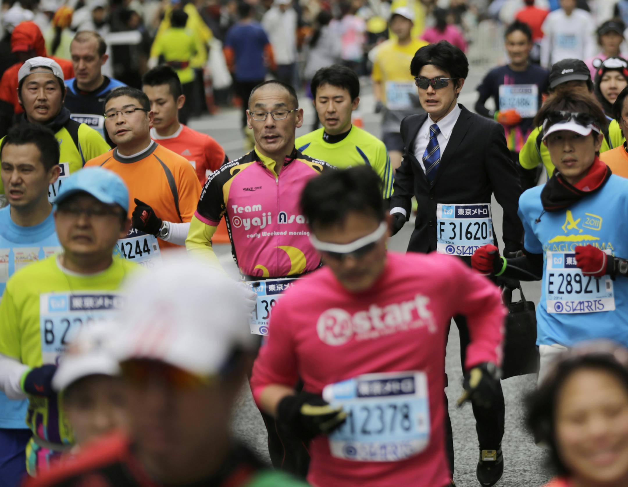 A runner wearing a business suit and a necktie races in the Tokyo Marathon in Tokyo Sunday, Feb. 23, 2014. (AP Photo/Eugene Hoshiko)