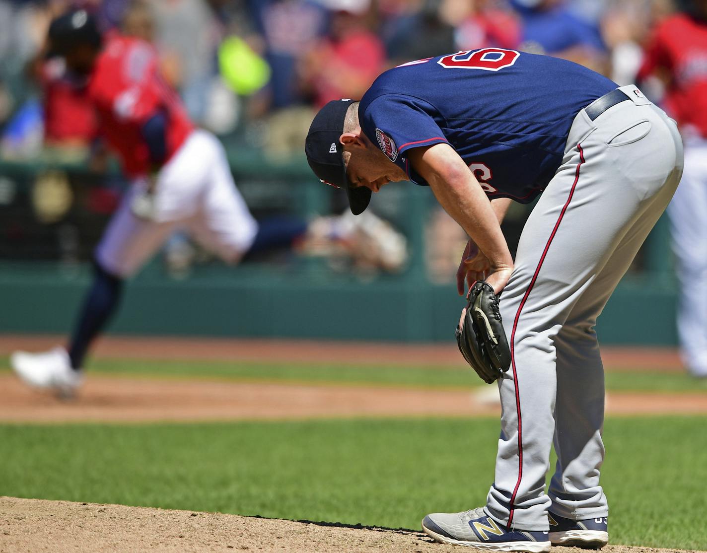 Minnesota Twins relief pitcher Trevor May, foreground, waits for Cleveland Indians' Carlos Santana to run the bases after hitting a solo home run in the seventh inning of a baseball game, Sunday, July 14, 2019, in Cleveland. (AP Photo/David Dermer)