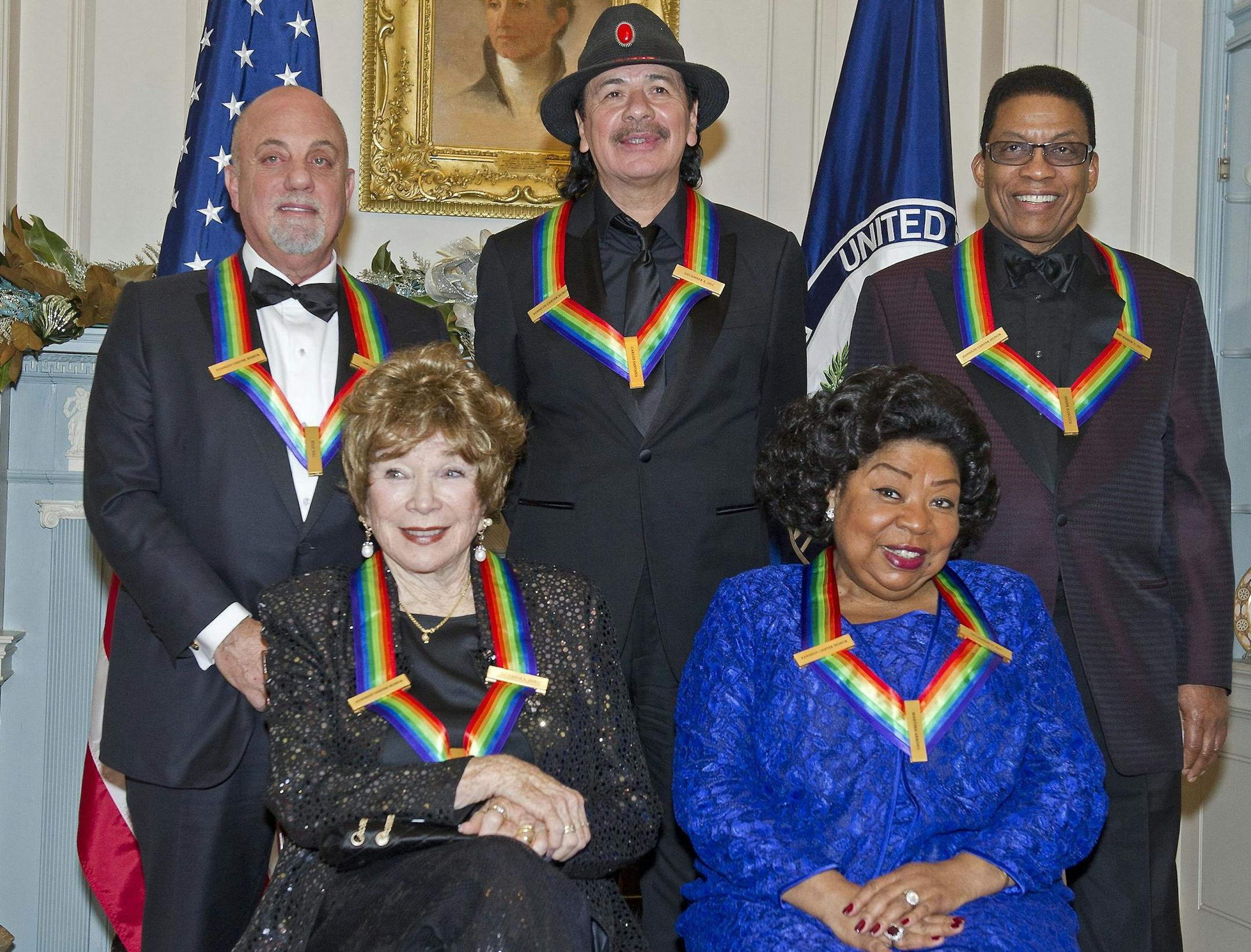 The five recipients of the 2013 Kennedy Center Honors pose for a photo following a dinner hosted by United States Secretary of State John F. Kerry at the U.S. Department of State in Washington, D.C. on Saturday, December 7, 2013. Seated in the front row, from left, are: Shirley MacLain, and Martina Arroyo. Standing, from left, are Billy Joel, Carlos Santana, and Herbie Hancock. The 2013 honorees are opera singer Martina Arroyo; pianist, keyboardist, bandleader and composer Herbie Hancock; pianis