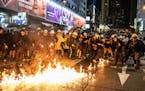 Pro-democracy demonstrators watch a firebomb in the Causeway Bay district of Hong Kong on Saturday, Aug. 31, 2019. Saturday saw some of the most inten