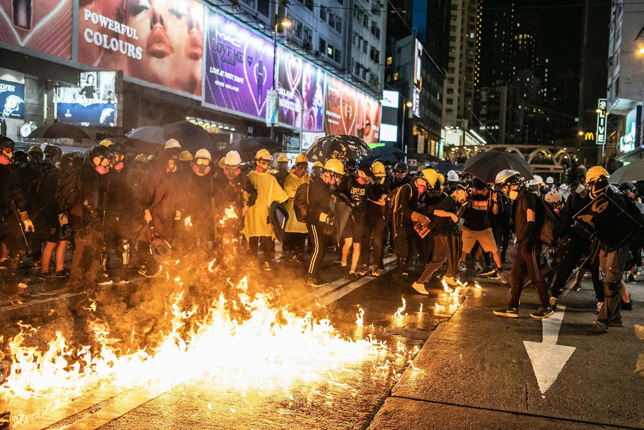 Pro-democracy demonstrators watch a firebomb in the Causeway Bay district of Hong Kong on Saturday, Aug. 31, 2019. Saturday saw some of the most intense clashes since the protests began. (Lam Yik Fei/The New York Times)