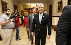 Republican Gov. Phil Bryant, right, walks past reporters on his way to a meeting of a youth jobs program board, at the Capitol in Jackson, Miss., Frid