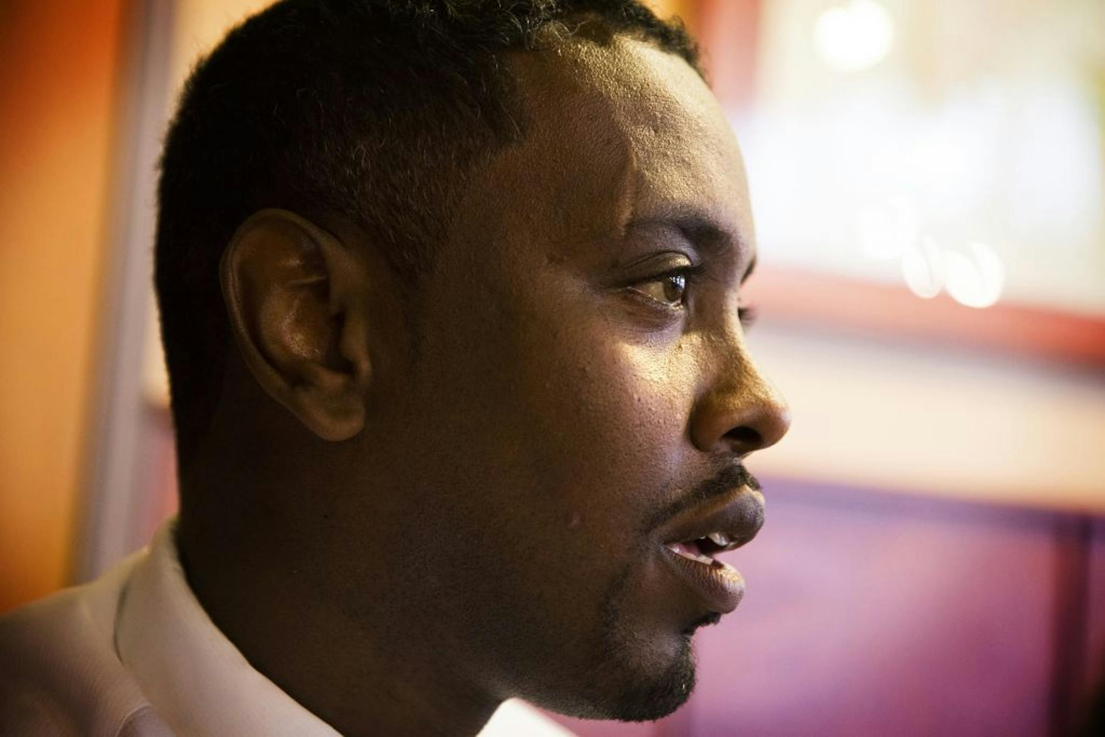 Minneapolis City Councilman Abdi Warsame talks with a young Somali-American at Mapps Coffee Riverside in Minneapolis on Friday, May 29, 2015.