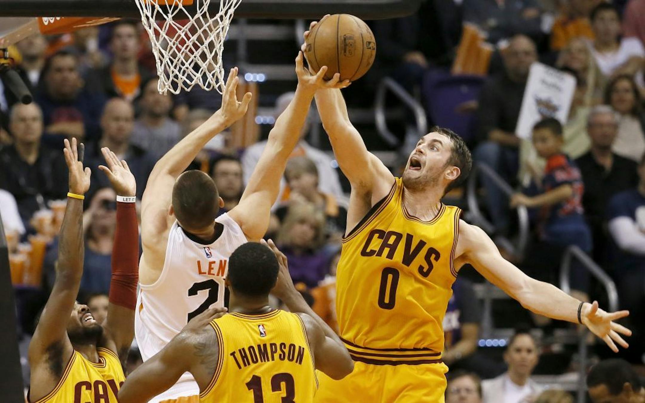 Cleveland Cavaliers' Kevin Love (0) block the shot of Phoenix Suns' Alex Len during the first half of an NBA basketball game, Tuesday, Jan. 13, 2015, in Phoenix.