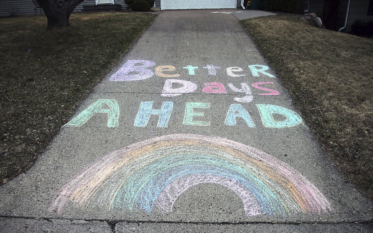 A chalk message and rainbow adorn a driveway with a positive message in the fight against the coronavirus at a Bloomington, Minn. home Wednesday, April 1, 2020, The new coronavirus causes mild or moderate symptoms for most people, but for some, especially older adults and people with existing health problems, it can cause more severe illness or death. (AP Photo/Jim Mone)