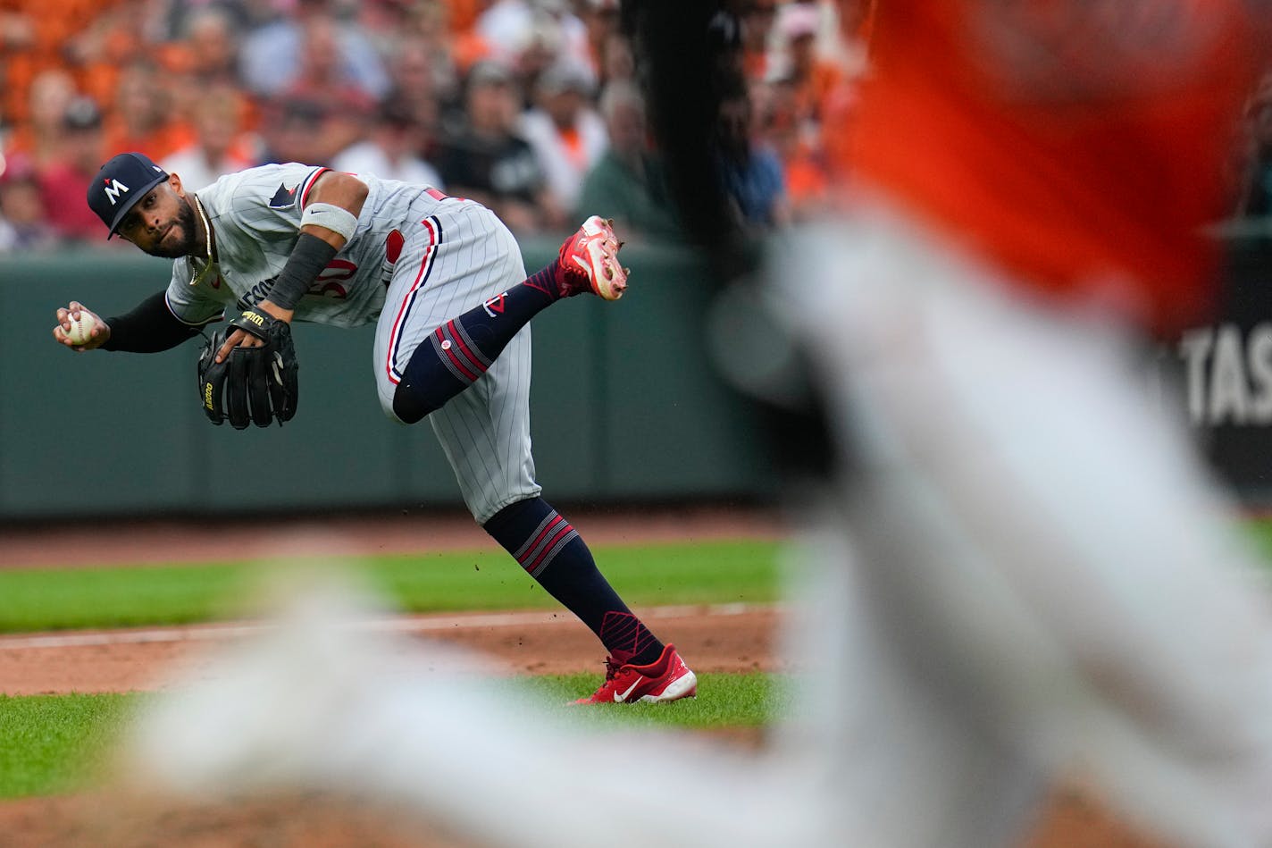 Minnesota Twins left fielder Willi Castro, left, tries to field an infield single by Baltimore Orioles' Adley Rutschman during the ninth inning of a baseball game, Saturday, July 1, 2023, in Baltimore. The Twins won 1-0. (AP Photo/Julio Cortez)