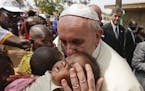 Pope Francis kisses a baby as he visits a refugee camp, in Bangui, Central African Republic, Sunday, Nov. 29, 2015. The Pope has landed in the capital