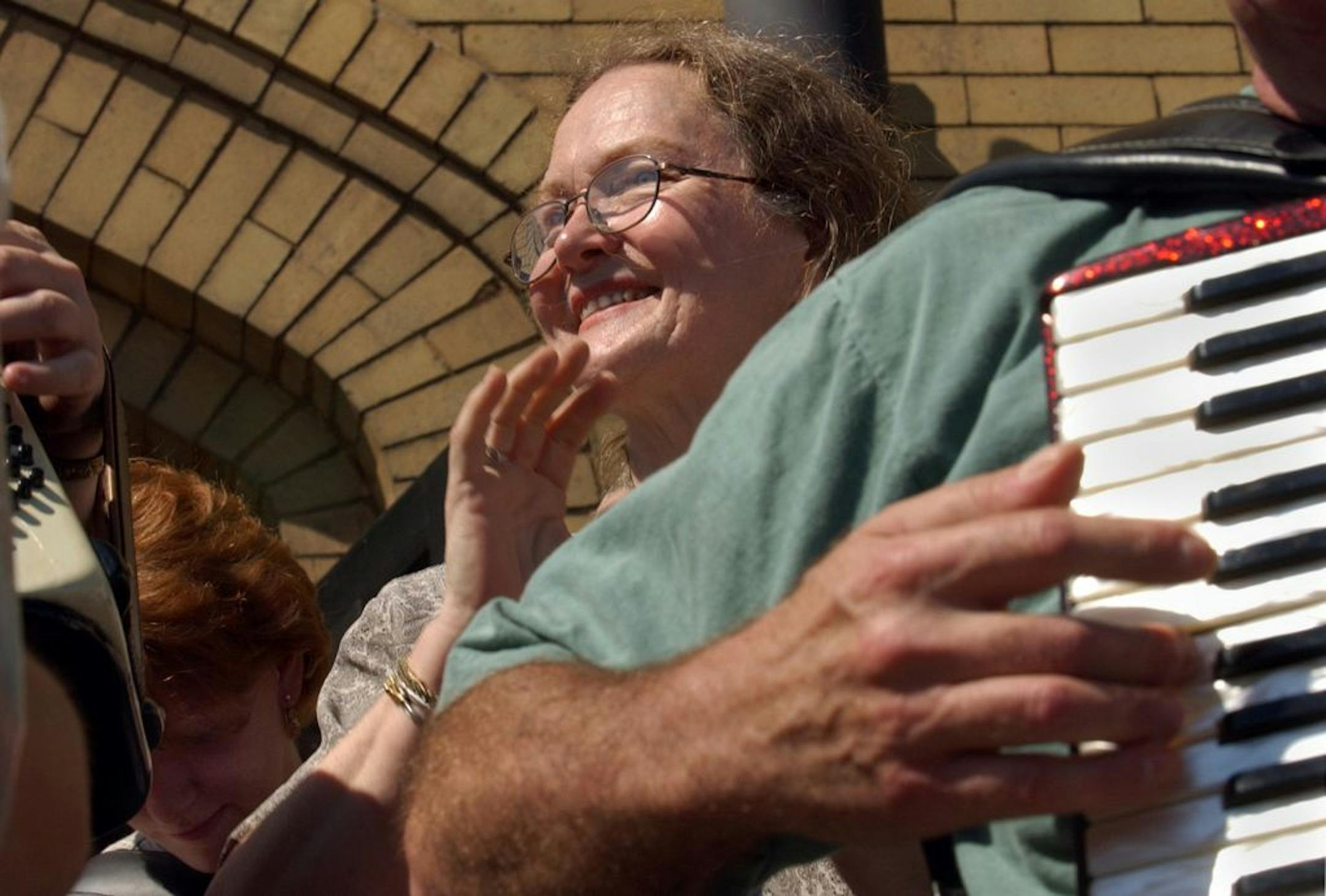 Superior, Wi., Fri., July 12, 2002--Helmi Harrington claps along as the American Accordionists' Association massed band plays on the steps of her "AWorld of Accordions Museum", the country's only accordion-specific museum. In addition to being curator of the museum, Harrington teaches 90 students each week, repairs accordions, is a ccordion instructor at the University of Wisconsin at Superior and directs Accordion Concertina Music Bands and performs with the Accordion Concertina Music Ensemble.