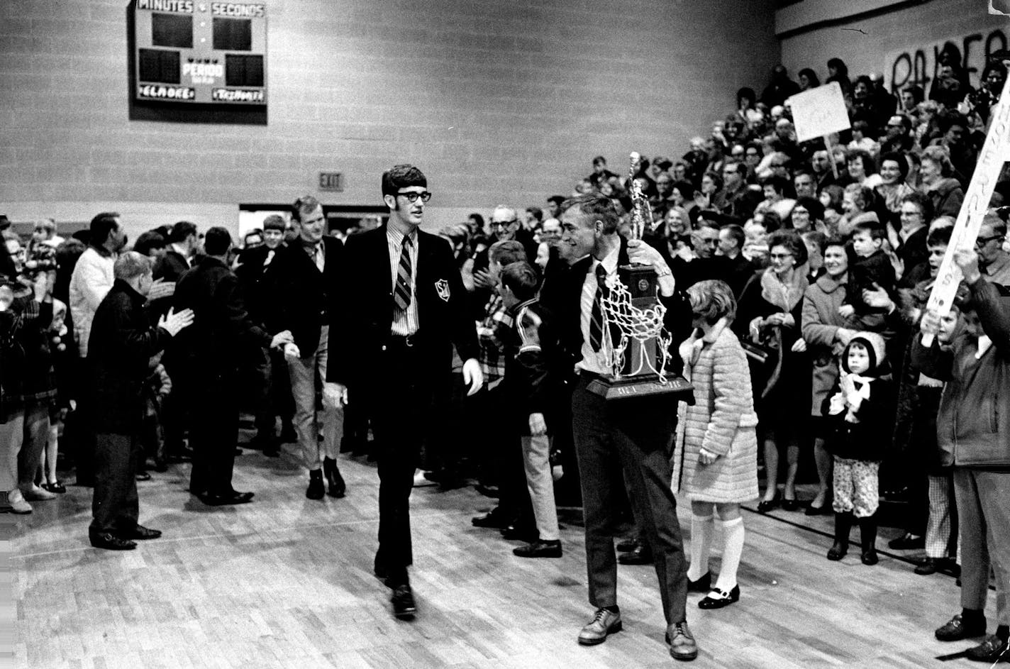 March 23, 1970 Coach Dennis Christofferson, with trophy, awaited Tom Mulso as Sherburn's champs pushed way into crowded gym in triumphant return. March 22, 1970 John Croft, Minneapolis Star Tribune