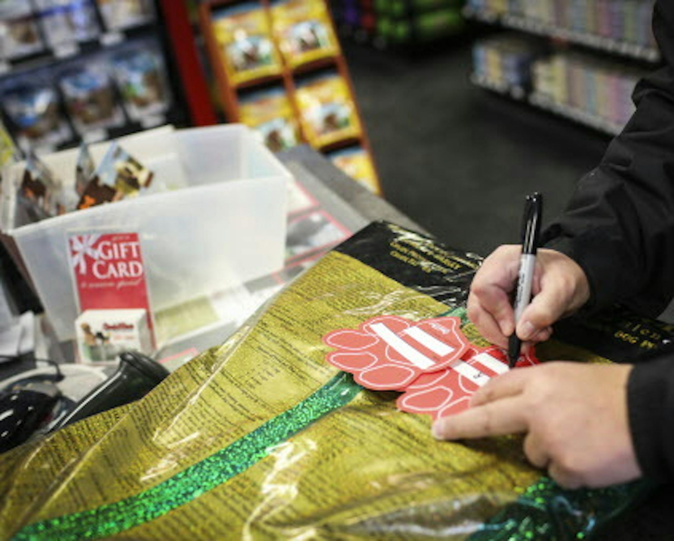 A woman filled out a paw print fundraising card at Chuck and Don's Pet Food and Supplies in Minneapolis, Minn. on Friday, December 19, 2014. ] REN&#xc9;E JONES SCHNEIDER reneejones@startribune.com