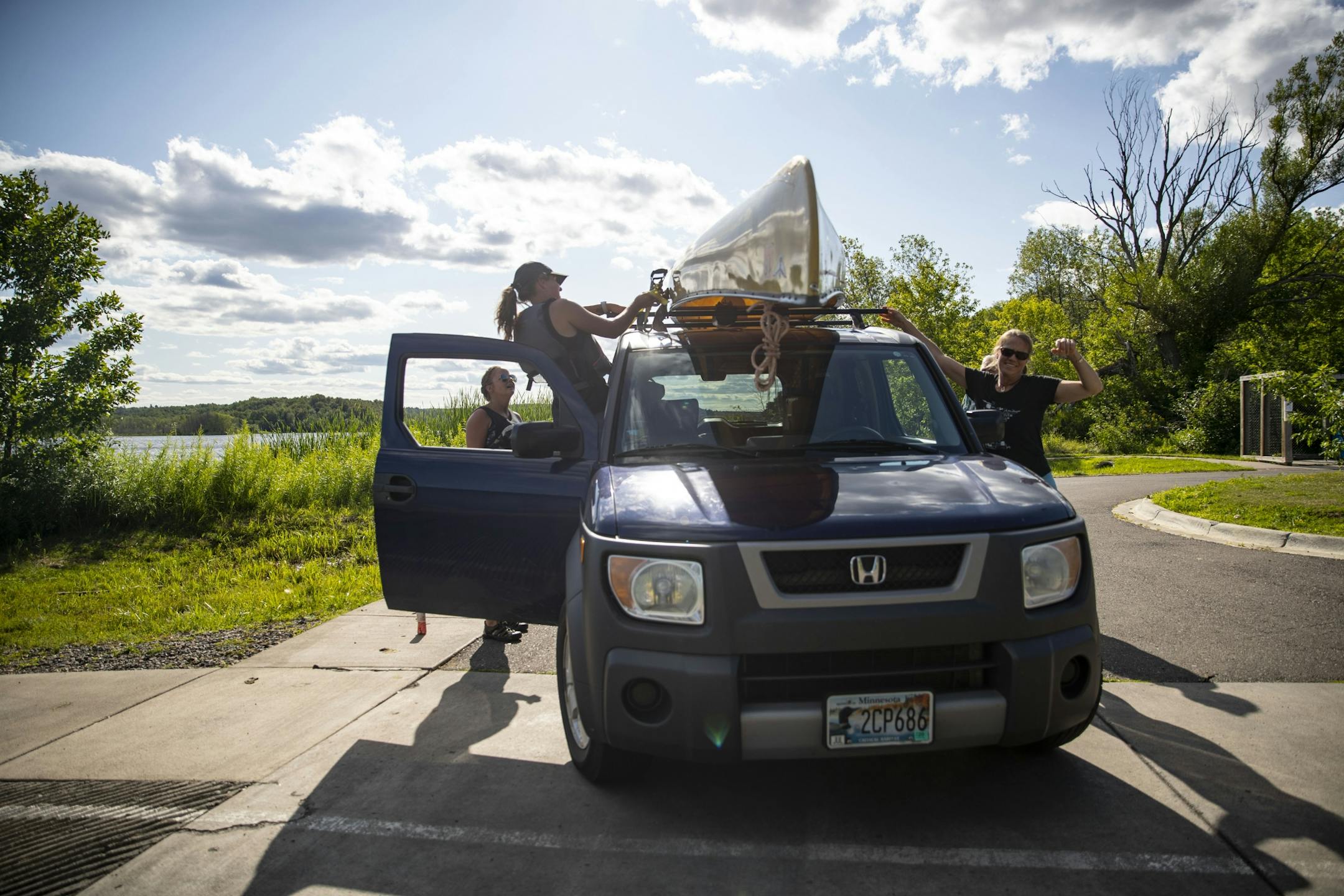 Wild Rice Monitors Robin Foro, left, and Katie Marsaa helped St. Louis River Alliance Program Director Tonia Kittelson take her canoe off her car before they set out on the estuary.