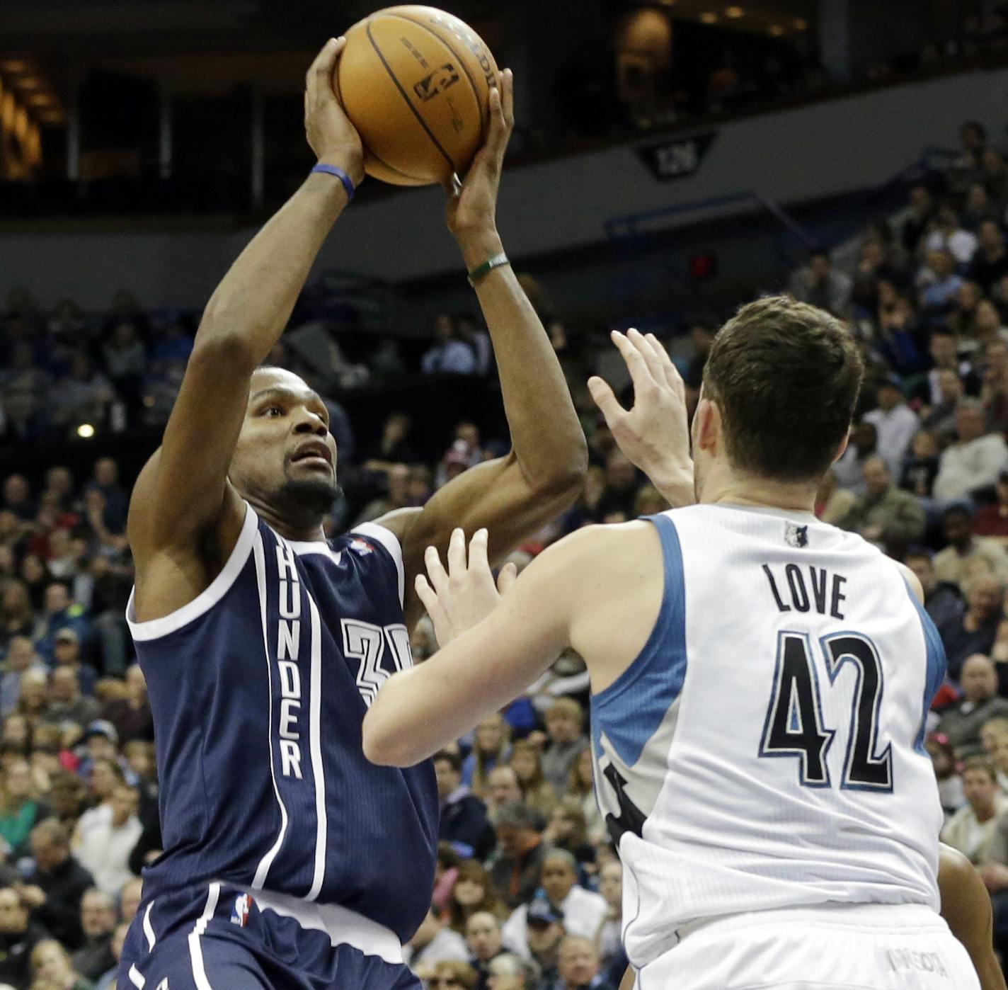 Oklahoma City Thunder's Kevin Durant, left, shoots as Minnesota Timberwolves' Kevin Love defends during the second half of an NBA basketball game Saturday, Jan. 4, 2014, in Minneapolis. Durant led the Thunder with 48 points in his team's 115-111 win. (AP Photo/Jim Mone)