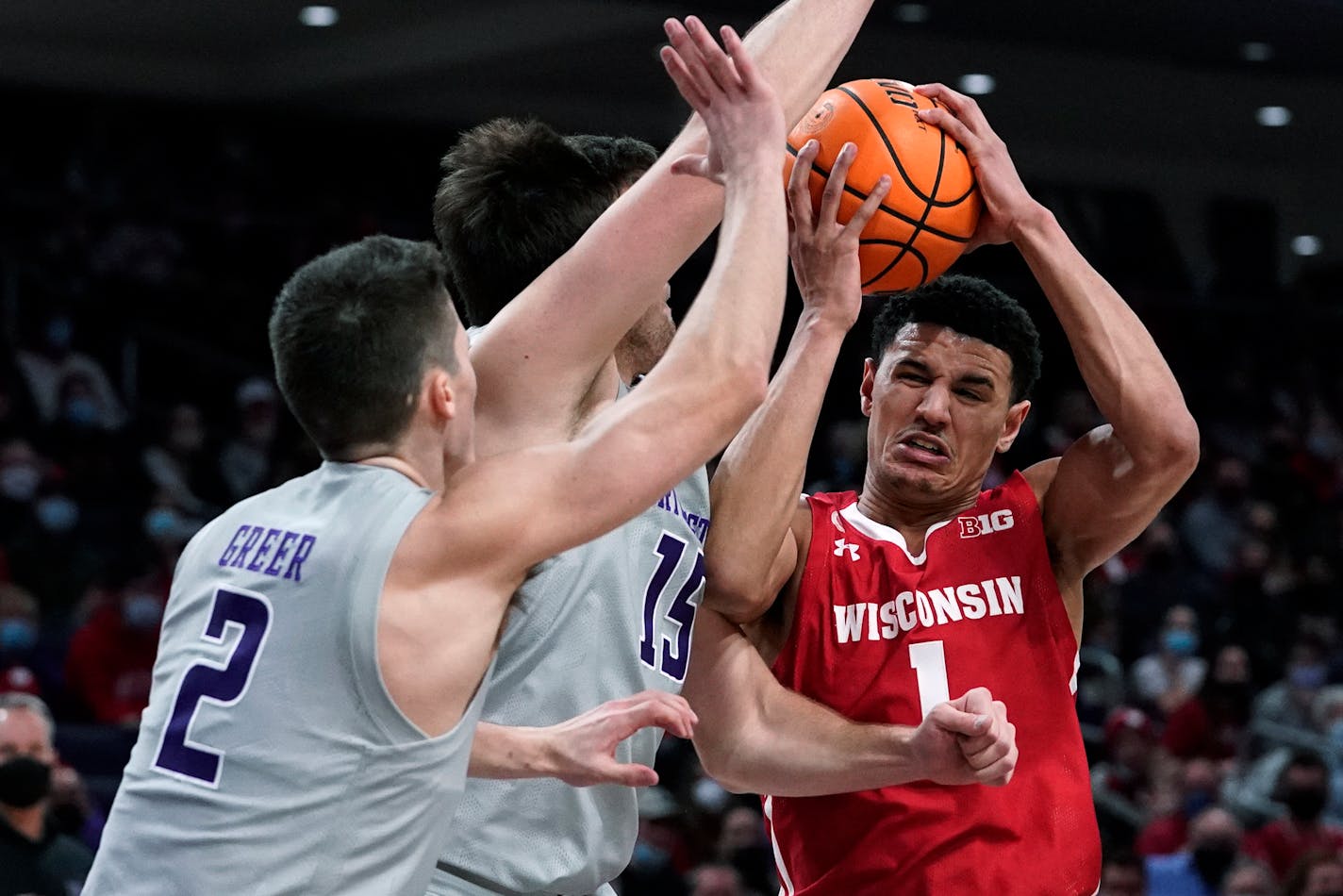 Wisconsin guard Johnny Davis drives to the basket against Northwestern guard Ryan Greer and center Ryan Young during the first half