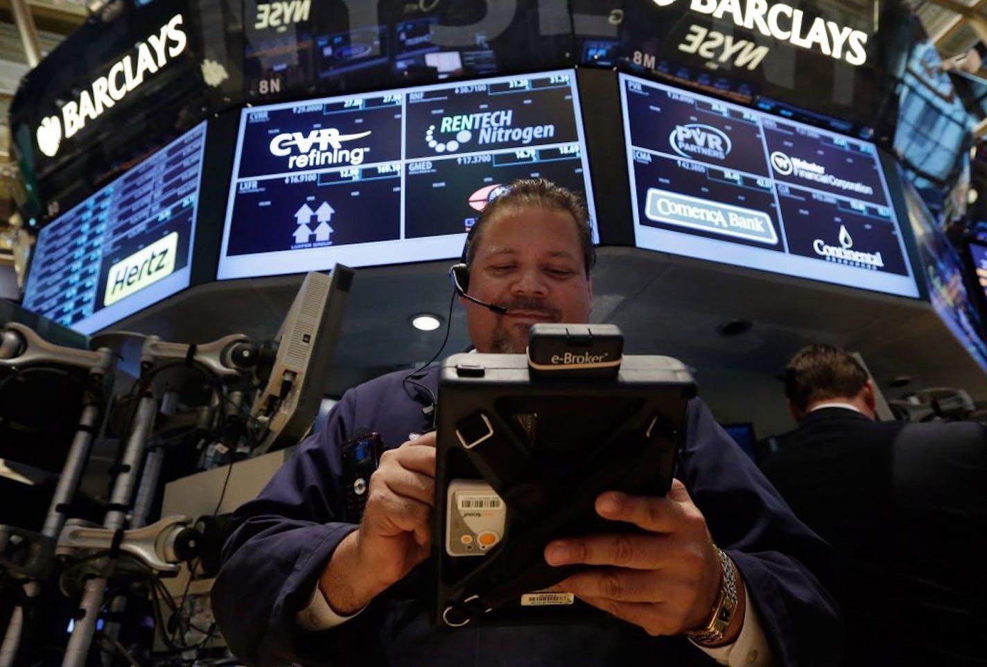 Trader John Santiago works on the floor of the New York Stock Exchange Monday, July 29, 2013.