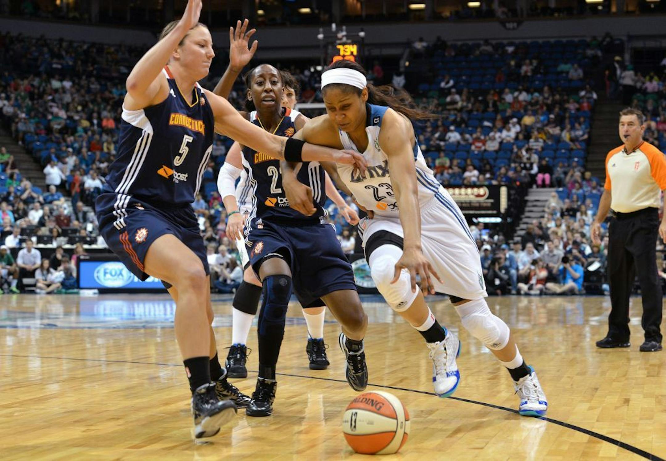 Minnesota Lynx forward Maya Moore rushes past Connecticut Sun's Kelsey Griffin (5) and Allison Hightower in Saturday's season opener.