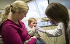 Hazel Johnson, 1, was held by her mother, Lacey Johnson, of Robbinsdale as Doctor of Dental Surgery, Kirsten Langguth, counted Hazel's teeth during a 