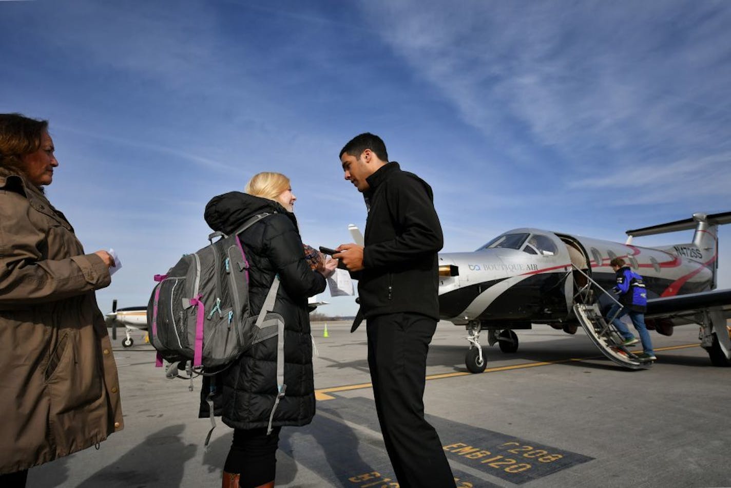 First officer Joshua Williams checked passengers boarding passes before the flight to Thief River Falls.