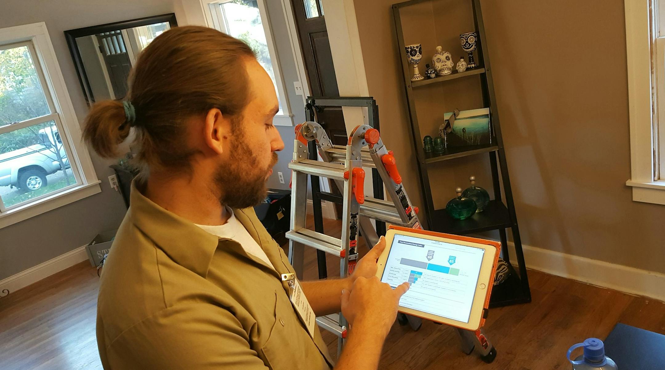 Andy Baeten, Center for Energy and Environment field operations manager, shows an energy effiicency scorecard for his own home in northeast Minneapolis. Photo by Shannon Prather